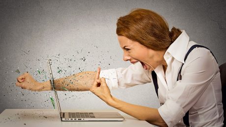 Side profile angry furious businesswoman throws a punch into computer, screaming. Negative human emotions, facial expressions, feelings, aggression, anger management issues concept