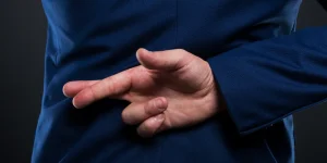 liar businessman standing with crossed fingers behind his back