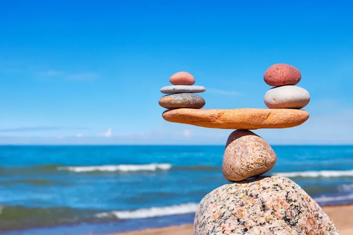 Rocks stacked like a see-saw, balanced just before a tipping occurs. licensed from 123rf.com