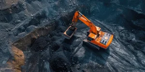 Coal mining pit. An excavator loads coal onto a truck